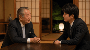 日本人の高齢の男性経営者（会長）と、親子ほど年の離れた若手社員が、和室で向き合って静かに語り合っている場面。夜、温かい照明。昔を懐かしむような穏やかな空気。写真風、ドキュメンタリーテイスト